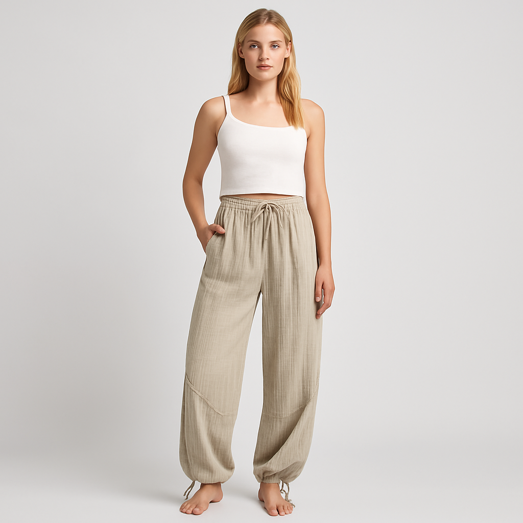 Light beige textured wide-leg lounge pants with drawstring waist and cinched hems, styled casually for relaxed wear.