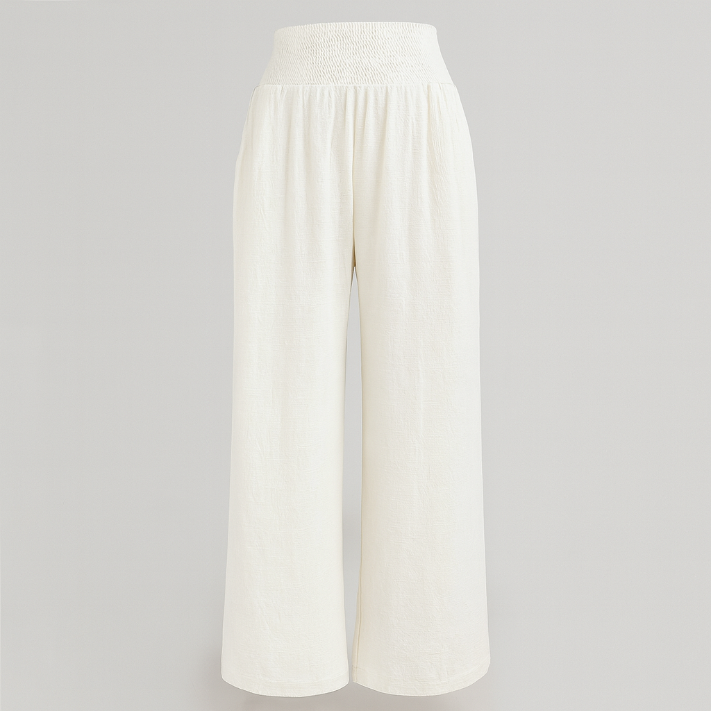 Wide-leg linen-blend pants with pleated front and smocked high waist, styled for relaxed summer beachwear