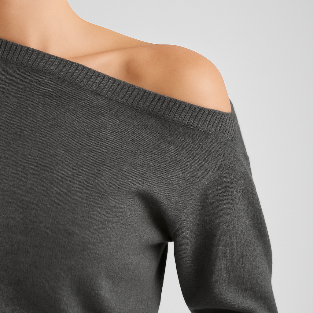 Charcoal grey off shoulder knit sweater with ribbed hem and cuffs, styled with a dark skirt for an edgy casual look