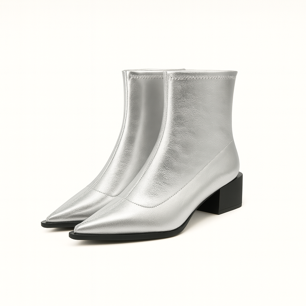 A pair of sleek ankle boots with pointed toes and low block heels. The boots have a glossy leather finish and a slim, fitted silhouette that hugs the ankle, creating a modern and elegant look.