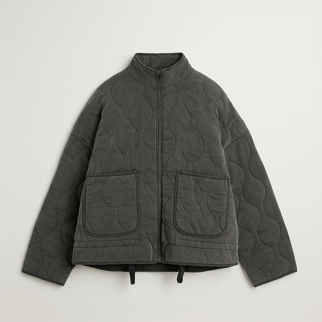 A quilted jacket featuring a high collar, full front zipper, and relaxed fit. Designed with wave-pattern stitching, two large front patch pockets, and adjustable drawstrings at the hem for a customizable fit. A minimalist yet functional outerwear piece perfect for layering in cooler weather.