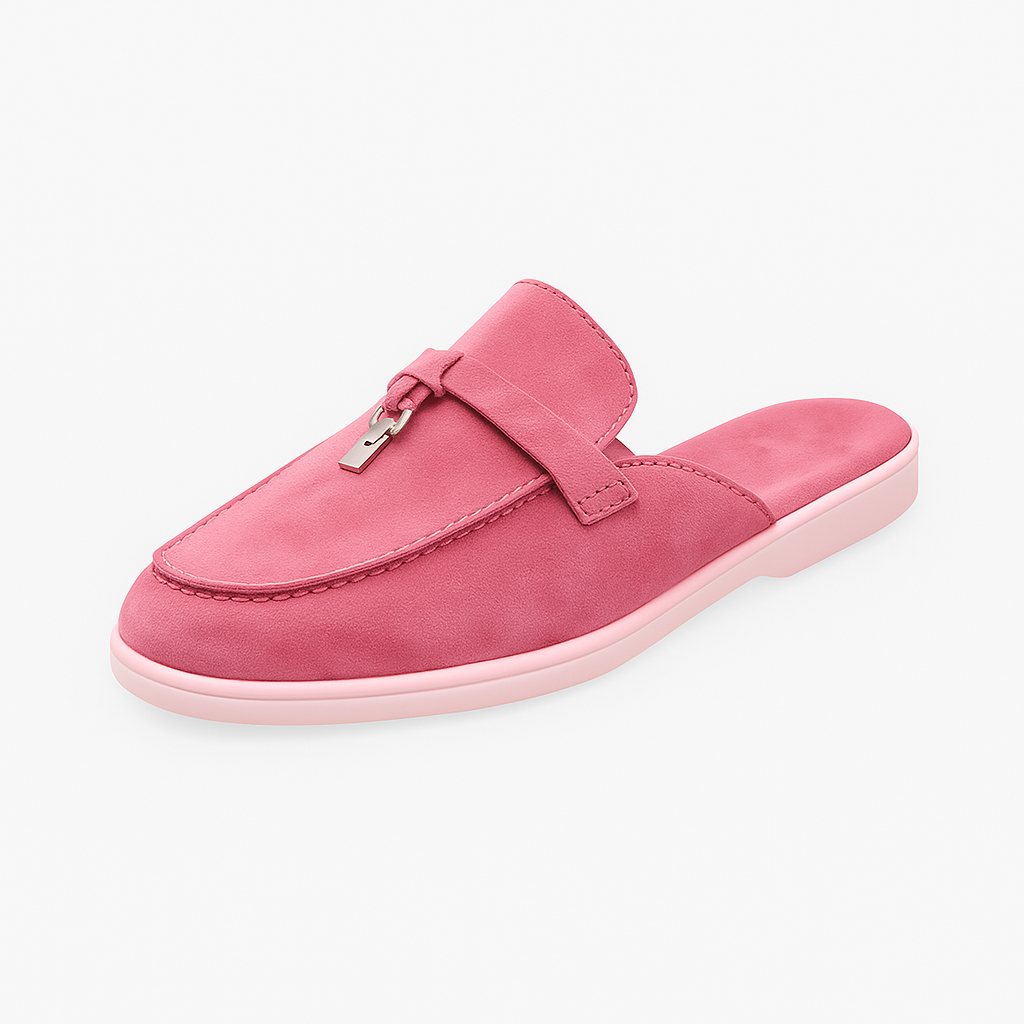 Suede mule loafer with a rounded toe, decorative strap, metal accent, and flat sole.