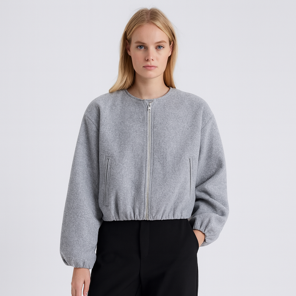 A zip-up jacket featuring a minimalist round neckline, dropped shoulders, and oversized balloon sleeves. The design includes front slit pockets and a gathered hem, creating a relaxed, casual silhouette perfect for layering in cool weather.