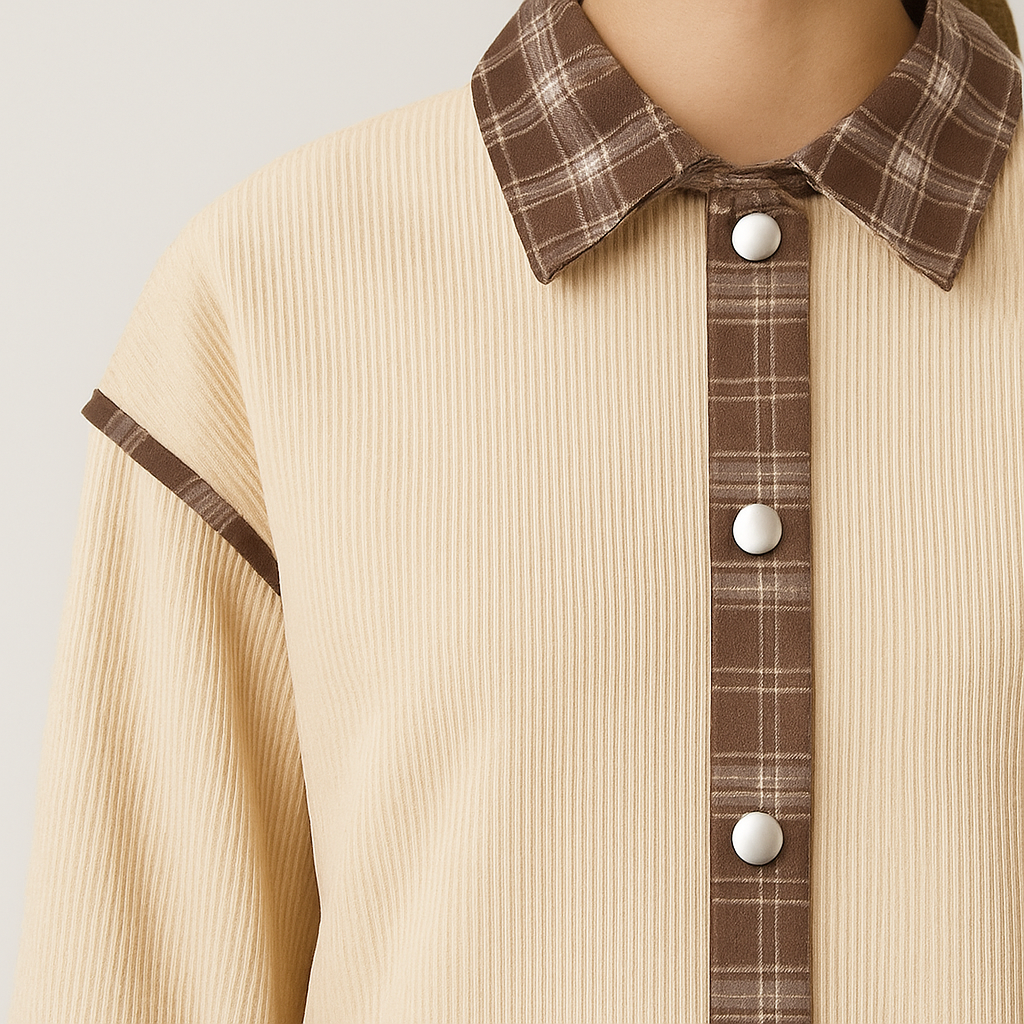 A beige corduroy jacket with plaid contrast trim on the collar, placket, cuffs, and hem, featuring a button-down front and long sleeves.