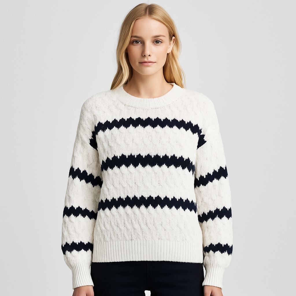 A white knit sweater with bold black zig-zag stripes, long balloon sleeves, and a ribbed crew neckline