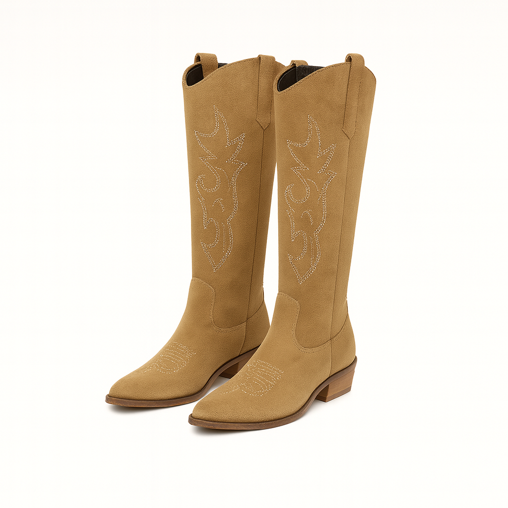 A pair of suede cowboy boots featuring decorative stitching on the shaft, pull tabs on the sides, and low stacked wooden heels. The boots have pointed toes and a classic Western-inspired silhouette.