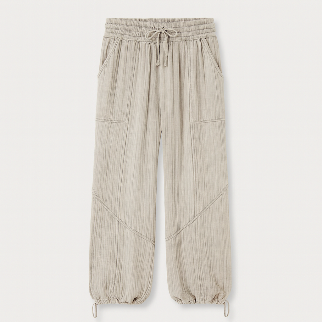 Light beige textured wide-leg lounge pants with drawstring waist and cinched hems, styled casually for relaxed wear.