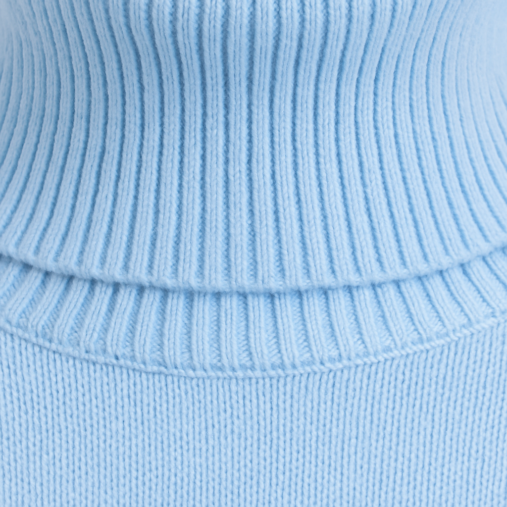 An oversized turtleneck sweater with long sleeves, ribbed cuffs, hem, and a tall ribbed fold-over neckline.