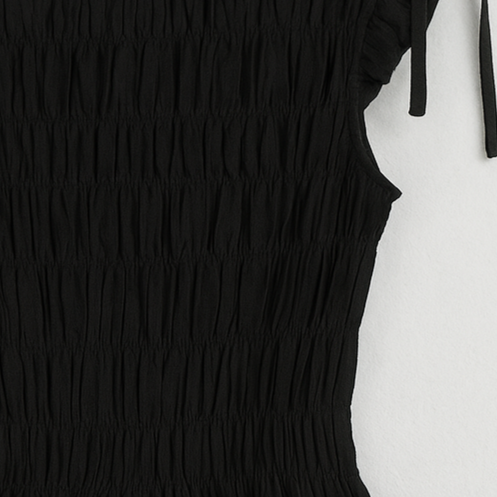 a black ruched top with bow-tie cap sleeves and a peplum hem