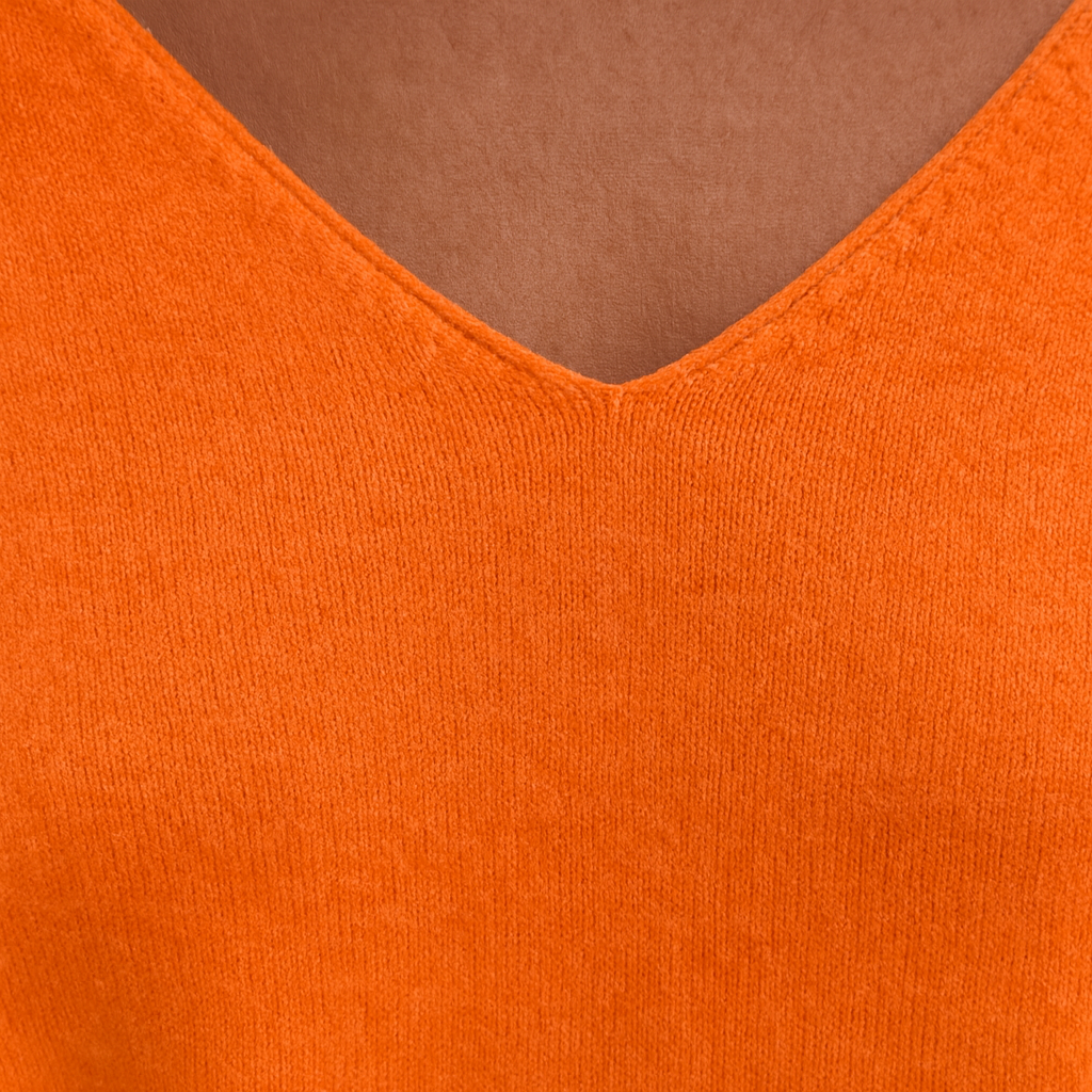 Oversized knit sweater with deep V-neck and long sleeves.