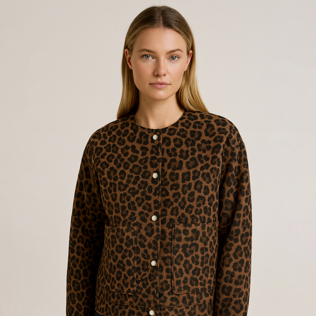Cozy leopard print jacket with button front, hip length, and relaxed fit, styled with dark jeans and a black top.