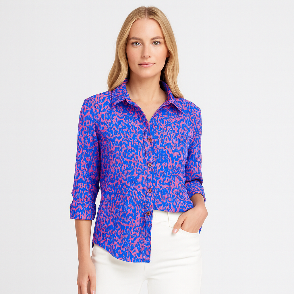 Button-up shirt with a bold blue and pink abstract animal print, featuring a pointed collar and long sleeves.