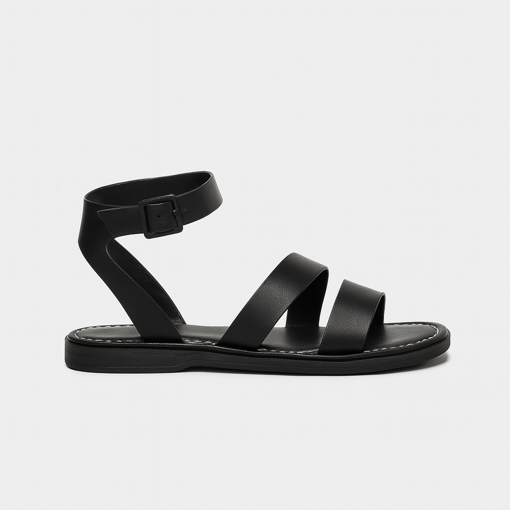 Flat sandal with wide straps, ankle buckle closure, and cushioned sole.