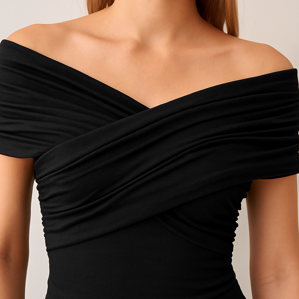 Black off shoulder wrap top with short sleeves and pointed hem, styled with denim shorts for a modern casual look