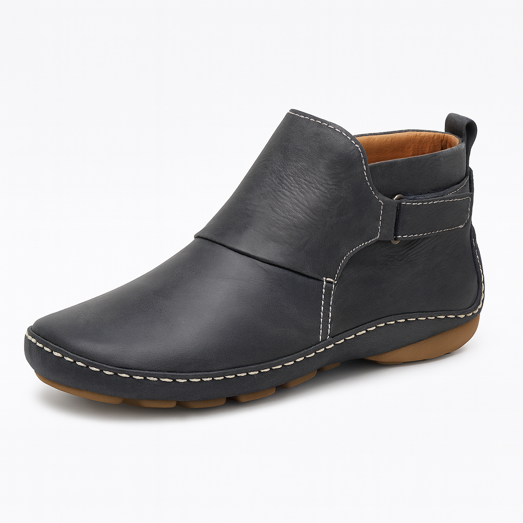 Ankle boot with slip-on design, contrast stitching, and flat sole.