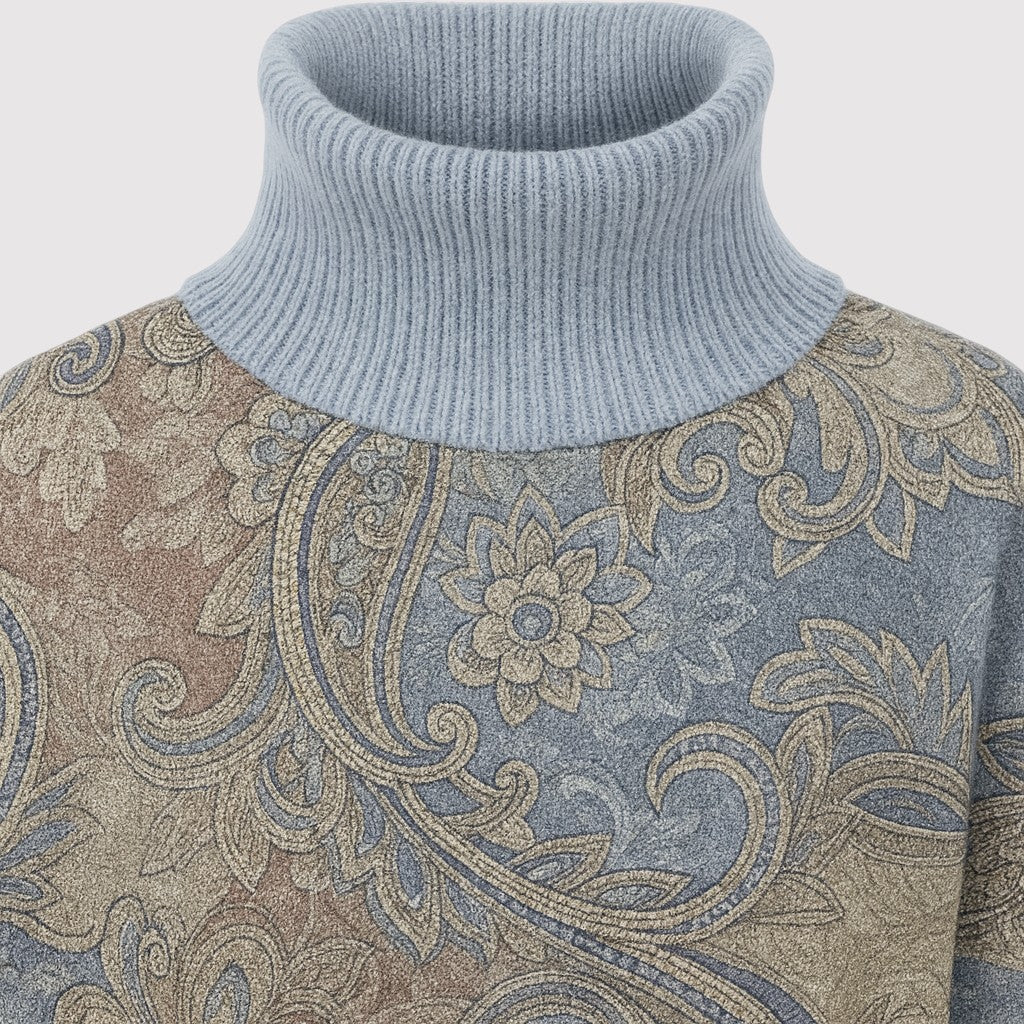 A patterned turtleneck sweater featuring intricate paisley and floral designs, with ribbed cuffs, hem, and a tall ribbed turtleneck.