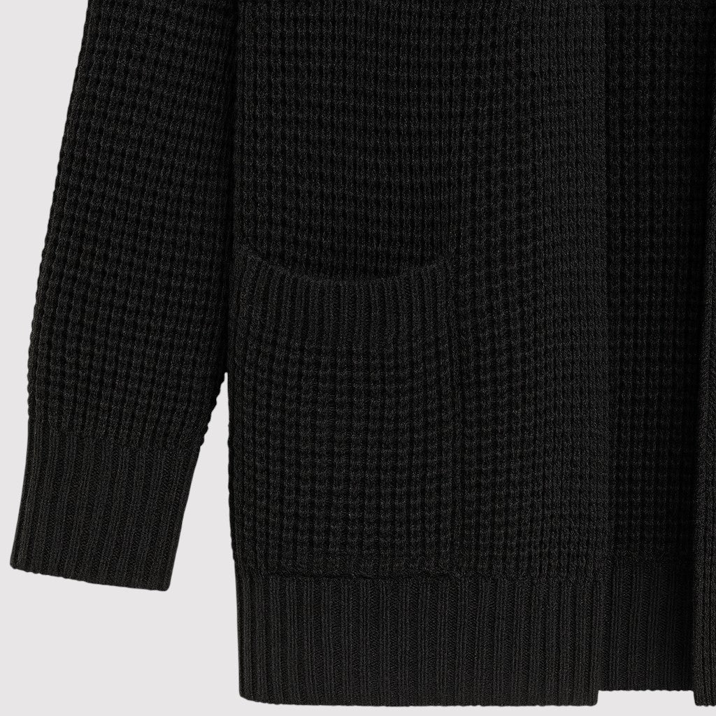 A long open-front knit cardigan with a textured waffle pattern, ribbed cuffs and hem, and two front patch pockets.