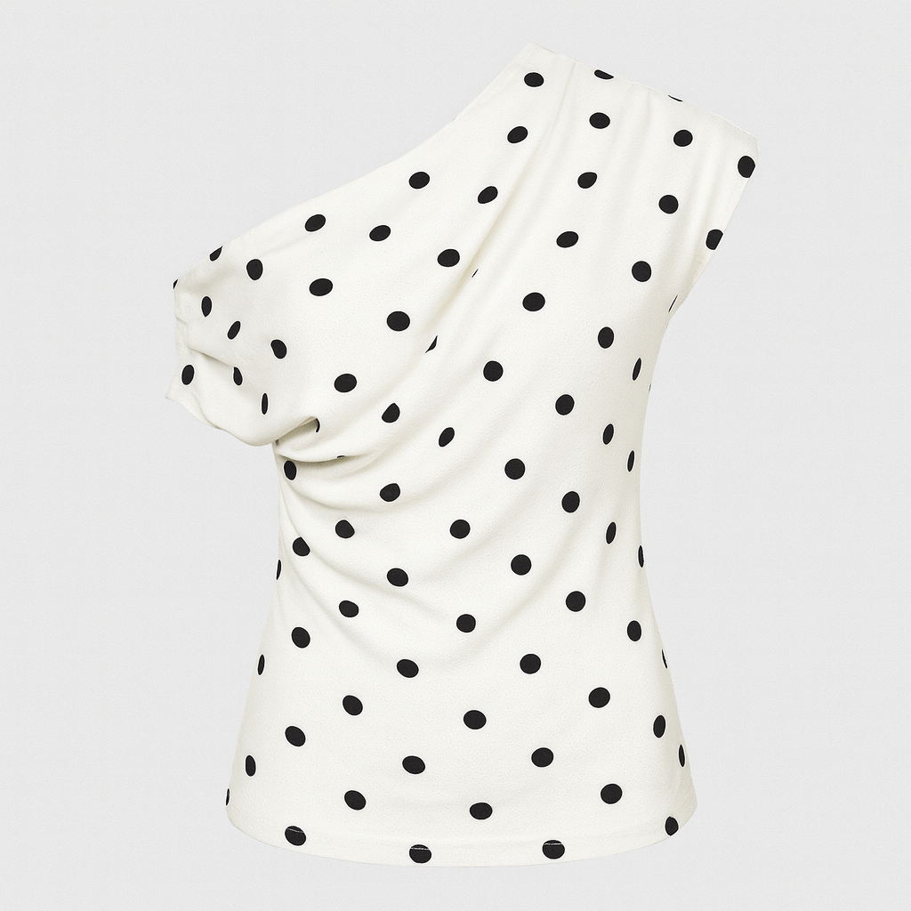 White one shoulder polka dot top with draped neckline, styled with white bottoms and statement accessories