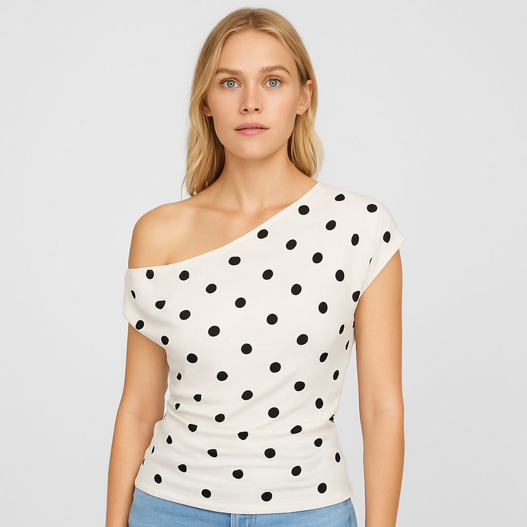 White one shoulder polka dot top with draped neckline, styled with white bottoms and statement accessories