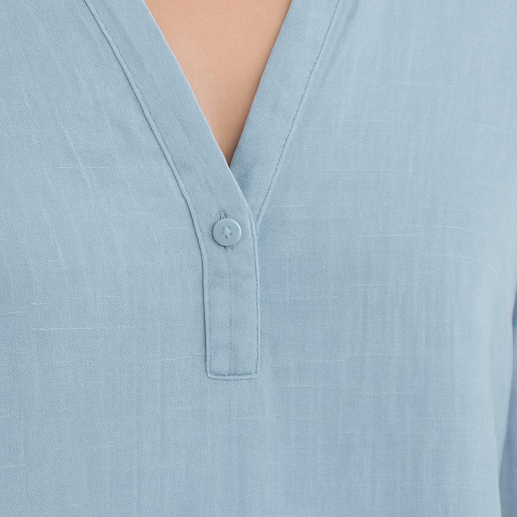 Light blue tunic blouse with notched V-neckline, flowy silhouette, and rolled sleeves.