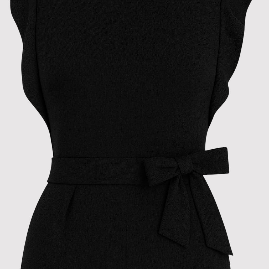 A sleeveless jumpsuit featuring ruffled shoulder details, a fitted waist with a matching fabric belt tied in a bow, and wide-leg pants for a chic and feminine silhouette.