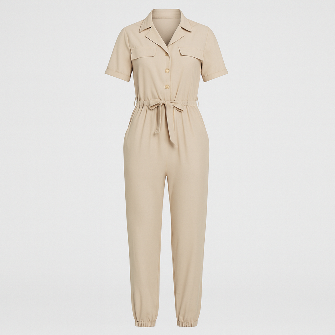 Utility jumpsuit with short sleeves, notched collar, button front, chest flap pockets, drawstring waist, and elastic cuffs at the ankles.
